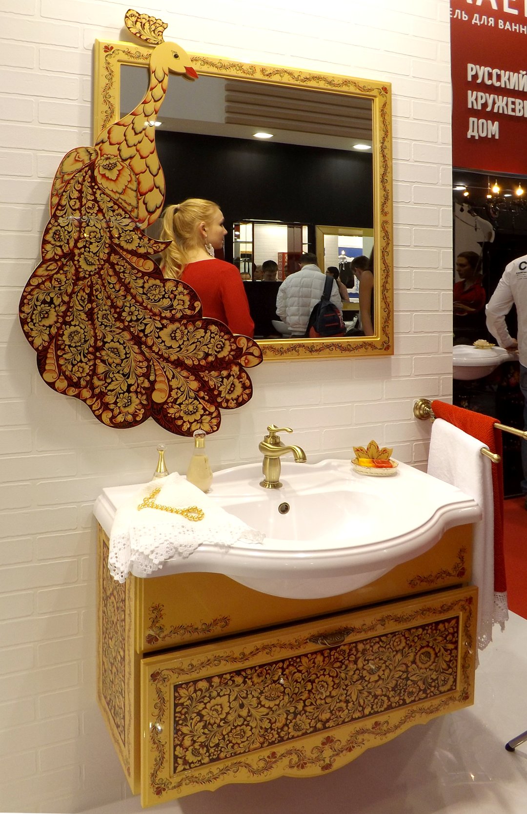 Раковина для ванной тумбой и зеркалом, украшенные рисунками на тему сказок о Жар-Птице, представленные на выставке MosBuild 2017 в Москве